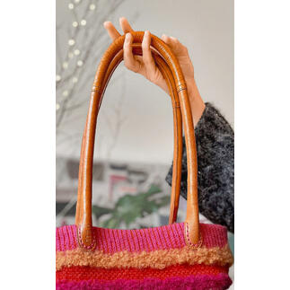 Taschengriff Bibi in Whisky-Farbe, gehalten von einer Hand, zeigt das Material und die Details.