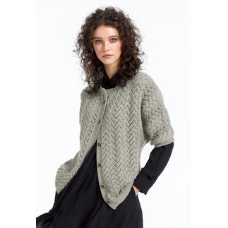 Frau in einer grauen Jacke aus Babyboomer, lächelnd, in schwarzem Kleid