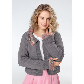 Frau in grauer Jacke aus Merino mit farbigen, pelzigen Akzenten, schaut direkt in die Kamera.