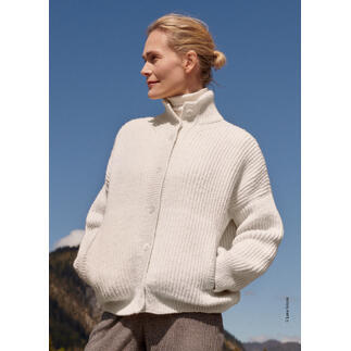 Frau trägt einen weißen Cardigan aus Alta Moda Alpaca von Lana Grossa unter blauem Himmel.