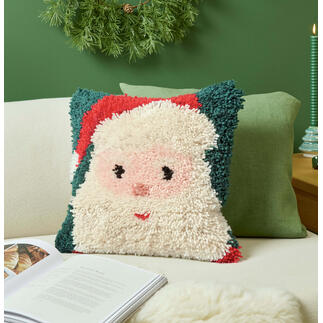 Santa-Kissen auf einer Couch mit grünen und beige Kissen.