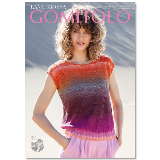 Modedesignerin mit lockigen Haaren in einem bunten Oberteil posiert für Gomitolo Heft.