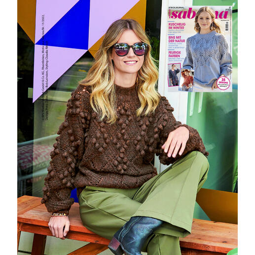 Dunkelbrauner Pullover mit auffälligem Muster und festlichen Details.