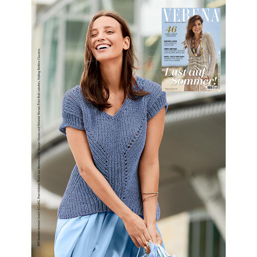 Pulli mit kurzem Arm in sanften Blautönen, getragen von einer Frau, lächelnd in urbanem Umfeld.