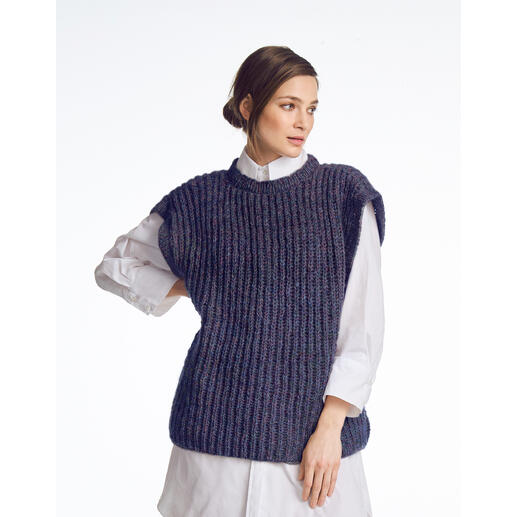 Frau in einem dunkelblauen Pullunder, trägt ein weißes Hemd darunter.