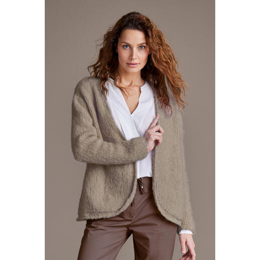 Junge Frau trägt eine beigen Jacke aus Nappy von Junghans-Wolle.