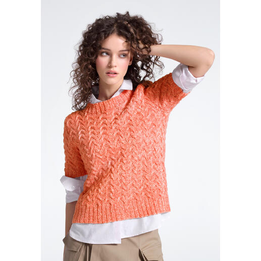 Frau in orangefarbenem Pullover aus Contrato posiert modisch.