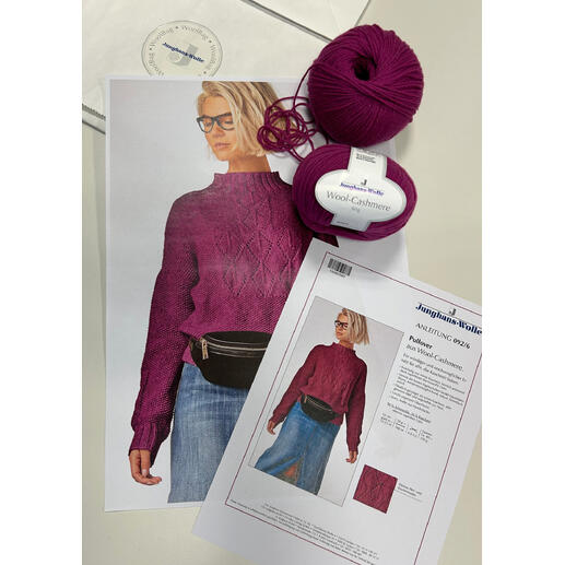 Bilder von einem lila Wollpullover, einer Packung Wolle und einer Anleitung auf einem Tisch.