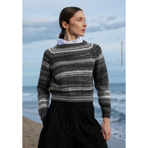 Pullover aus Merino Seta Tones, getragen von einer Frau am Strand.