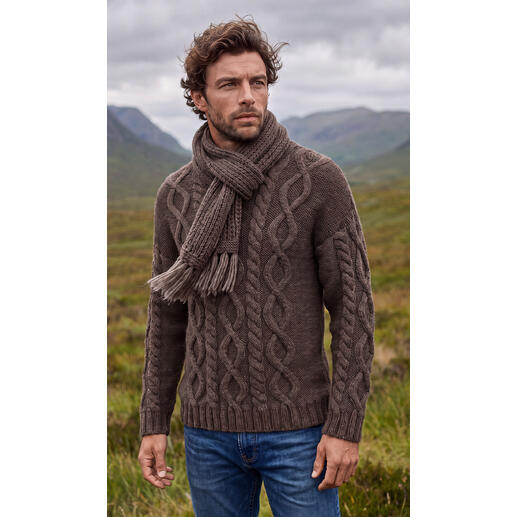 Herrenpullover aus Nova-Lana in Braun mit Zopfmuster und Schal im Freien.