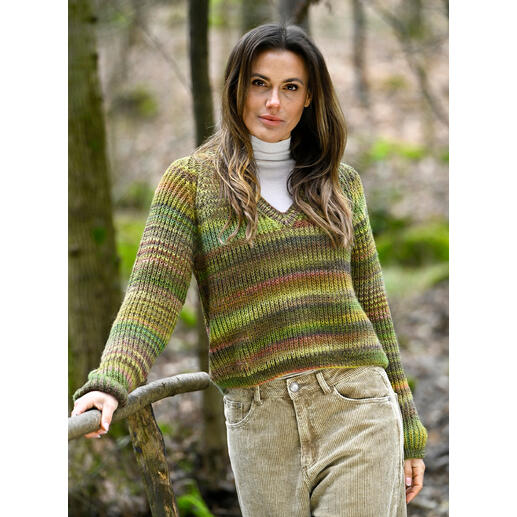 Grüner Pullover aus Linie 566 Trento, Modell steht in der Natur.