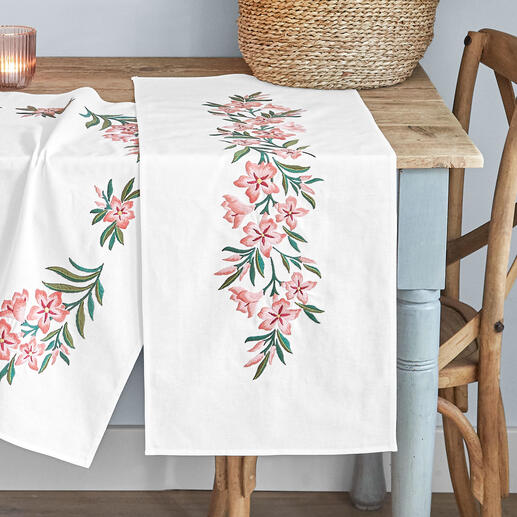 Tischläufer mit Olivensten-Blumenstickerei auf einem Tisch