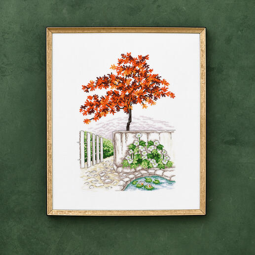 Kreuzstichbild eines Japanischen Ahorns und Zaunwinden im Garten.