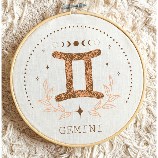 Minimalistische Stickerei des Sternzeichens Zwillinge mit floralen Motiven.