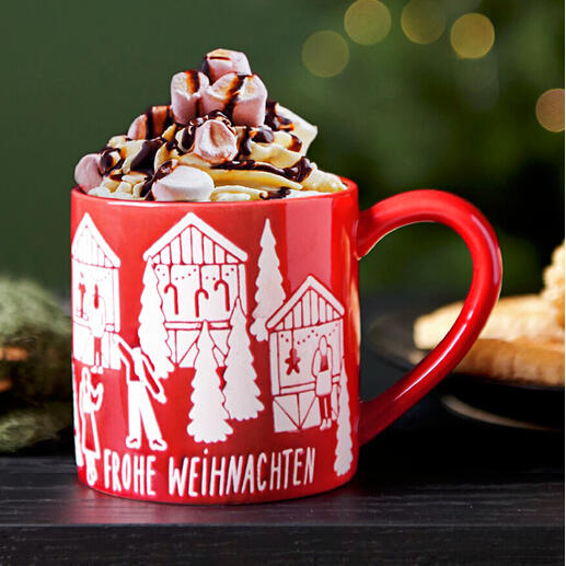 Rote Porzellan-Tasse mit Weihnachtsmotiv und Sahnehaube.