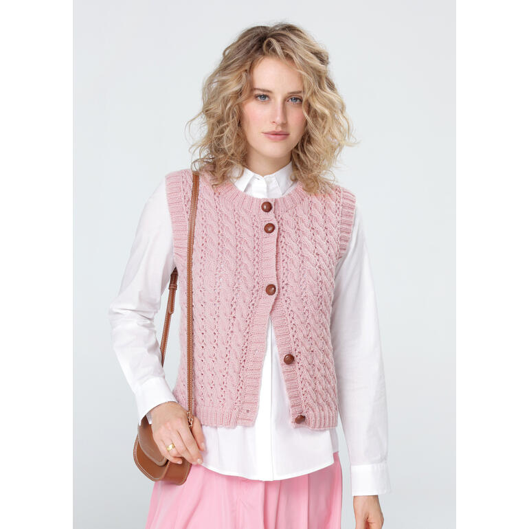 Frau in zart rosa Weste mit Knöpfen, kombiniert mit einer langen blauen Jeans.