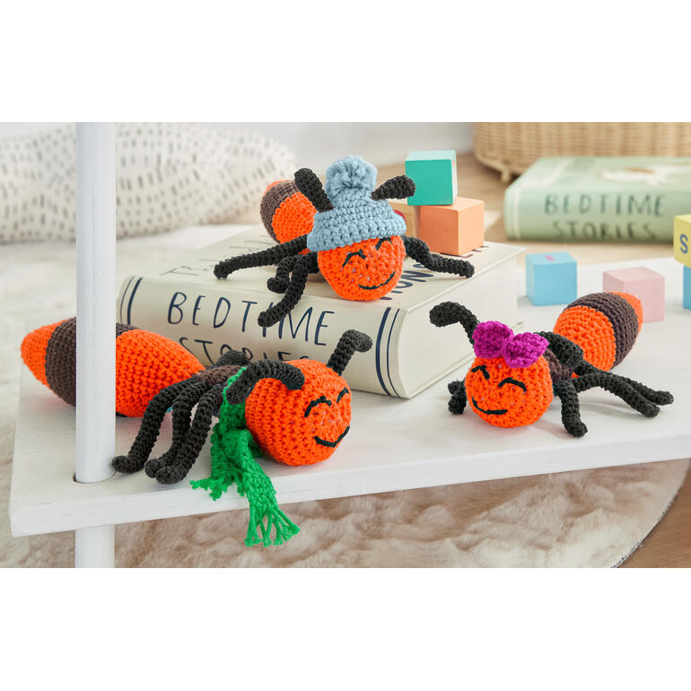 Vier gehäkelte Ameisen „Horst“, „Johannes“ und „Olivia“ mit bunten Hüten und Accessoires.