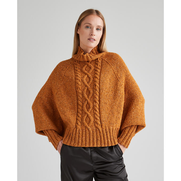 Anleitung für Poncho-Pullover aus Punktino, Modell in orange, lässig getragen.