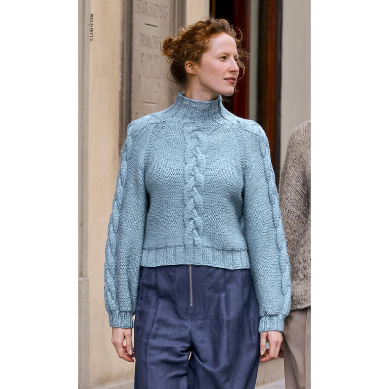 Frau in einem hellblauen Pullover aus Alta Moda Alpaca von Lana Grossa auf der Straße.