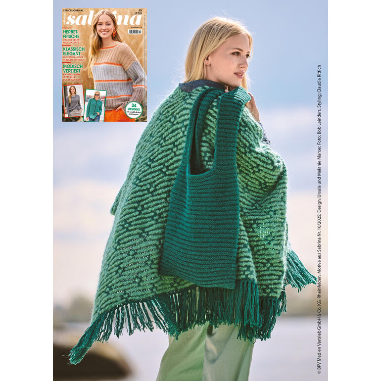 Frau mit Poncho und Tasche aus Nappy, vor einer hellen Landschaft.