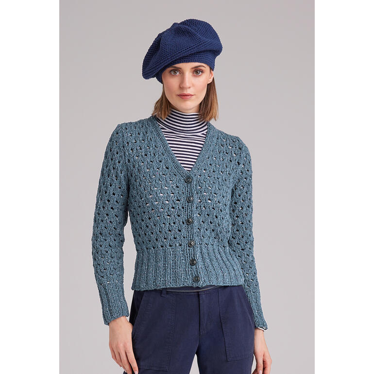 Frau in gestrickter Jacke aus Punktino mit stilvollem Hut.