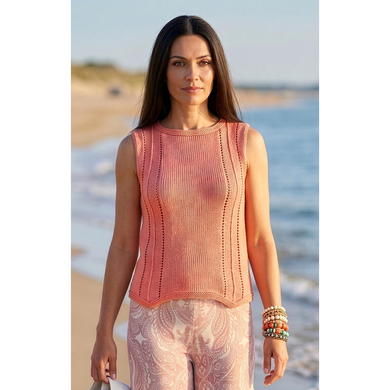 Frau in einem rosafarbenen Top aus Cotonia-Mezzo am Strand.