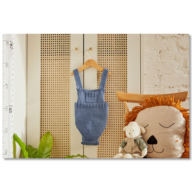 Blauer Babystrampler hängt an einer Holzstange.