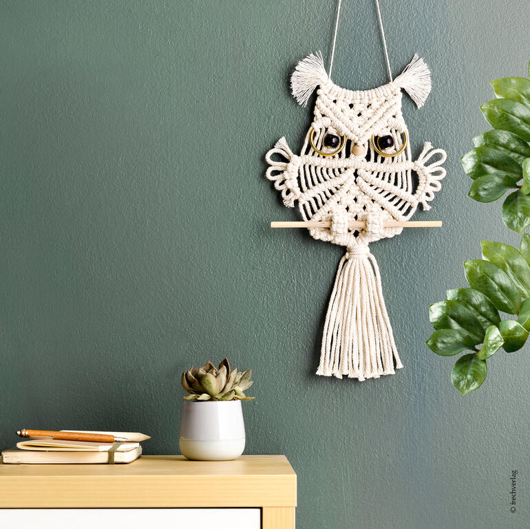 Makramee-Set mit Wandbehang in Form einer süßen Eule auf grünem Hintergrund.