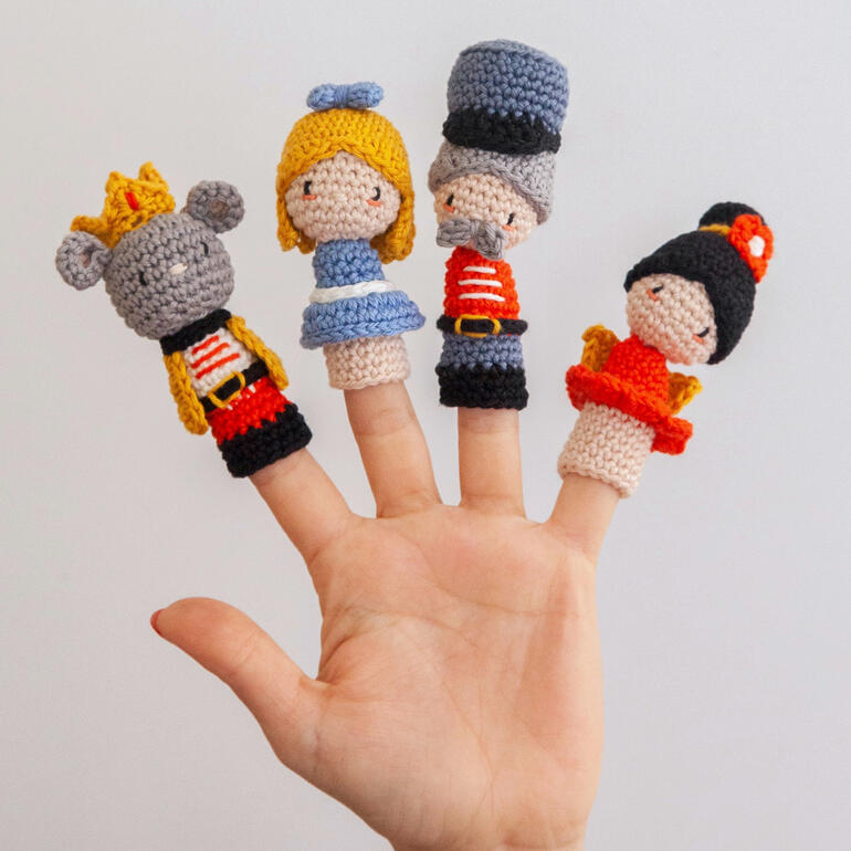 Fingerpuppen von Nussknackern aus Häkelmaterial auf einer Hand.