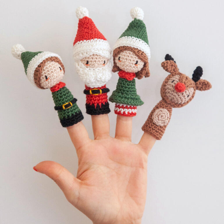Fingerpuppen von Weihnachtsfiguren, darunter ein Christbaum und ein Rentier.
