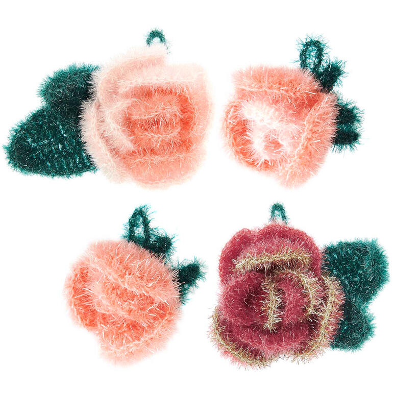 Drei gehäkelte Rosen in orange und rot auf einem weißen Hintergrund.