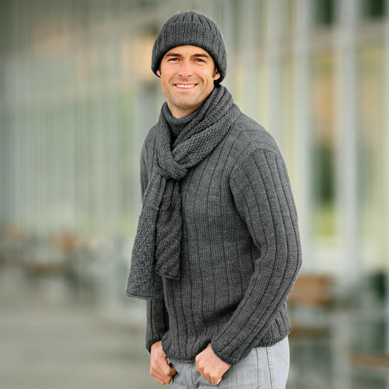 Mann trägt einen grauen Rollkragenpullover, Mütze und Schal, im Freien.