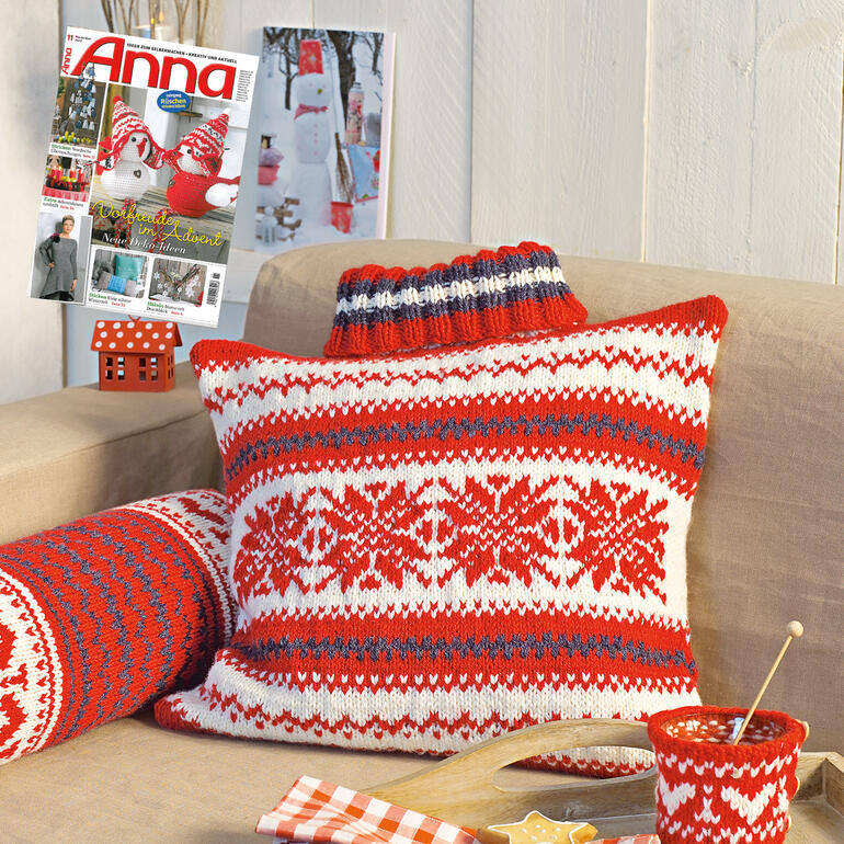 Dekoratives Kissen mit rot-weißer Musterung im Hintergrund