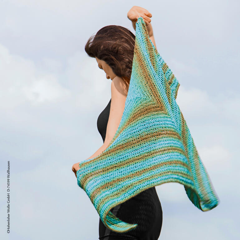 Frau hält ein farbenfrohes Tuch aus Gradient von Schoppel Wolle in den Händen.