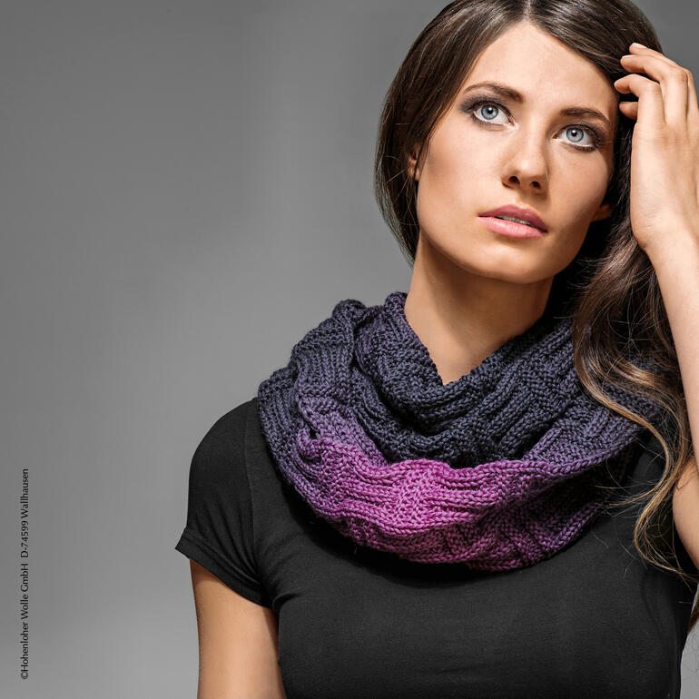 Frau trägt einen Loop aus Gradient von Schoppel Wolle um den Hals.