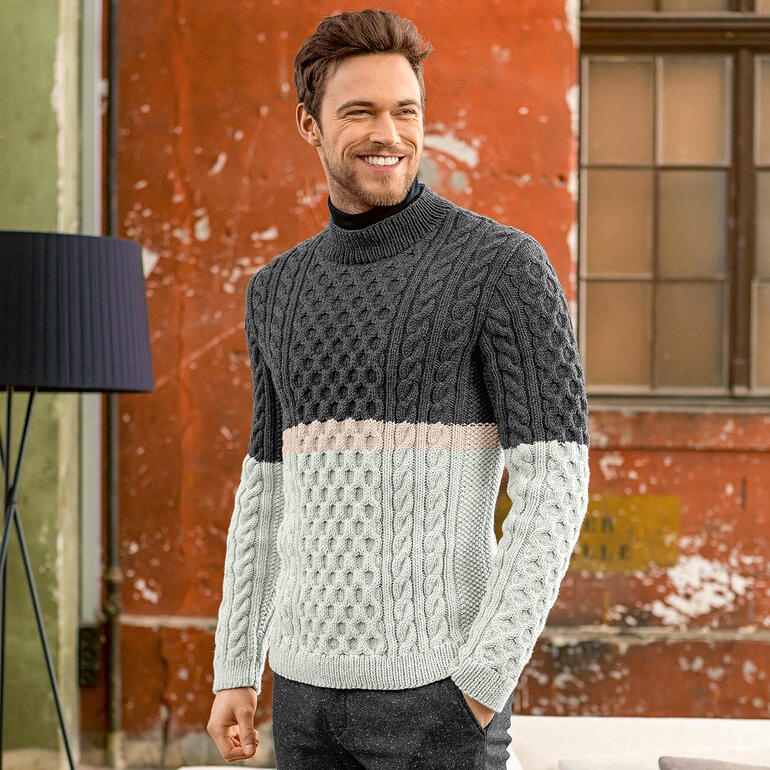Mann in einem grauen Strickpullover mit gemusterter Vorderseite.