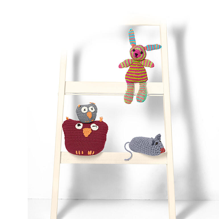 Gehäkelte Tiere auf einer Leiter, einschließlich einer Maus und einer Eule.