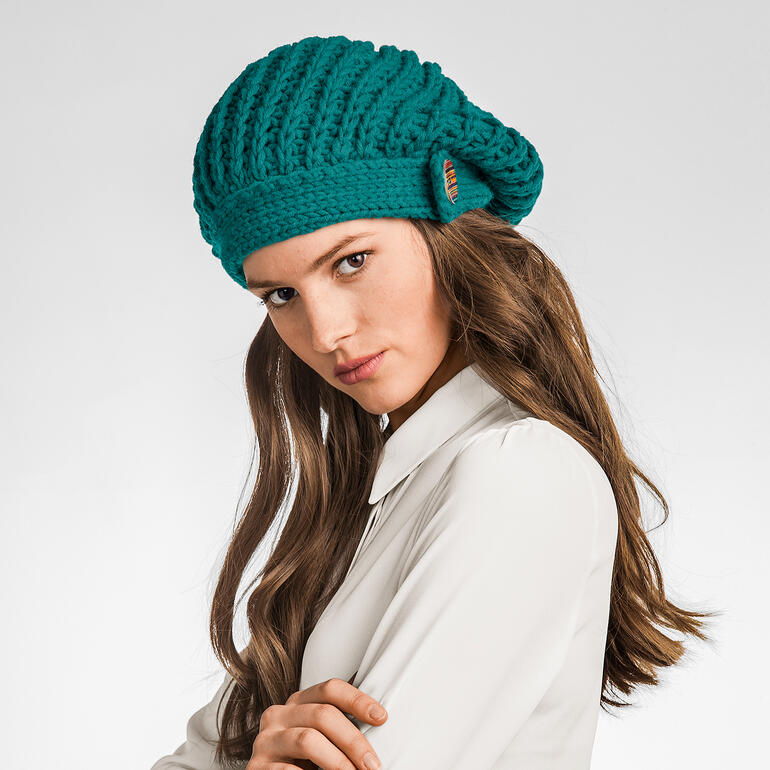 Mütze aus Merino Dick in kräftigem Grün, elegant gestyled.