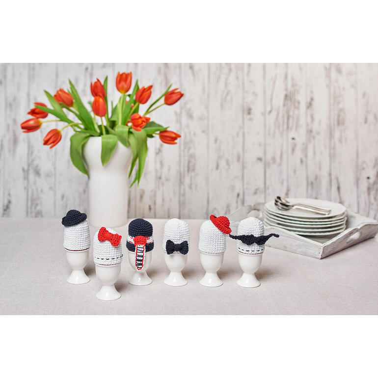 Eierwärmer aus Cotonia II, dekoriert in Form von verschiedenen klassischen Hüten.