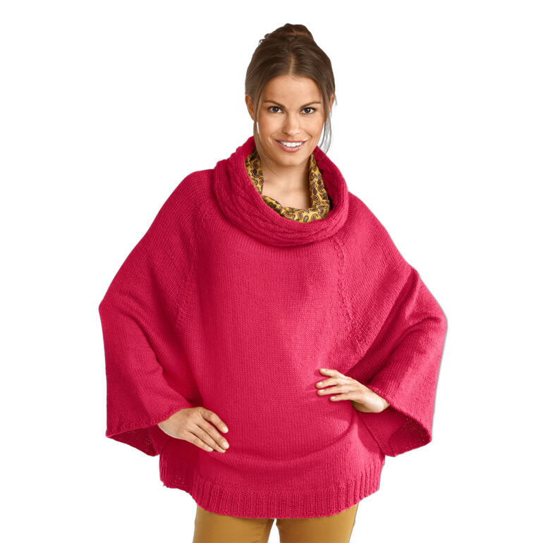 Dame trägt ein rosa Cape-Pullover aus Peru, steht entspannt mit erhobenen Armen.