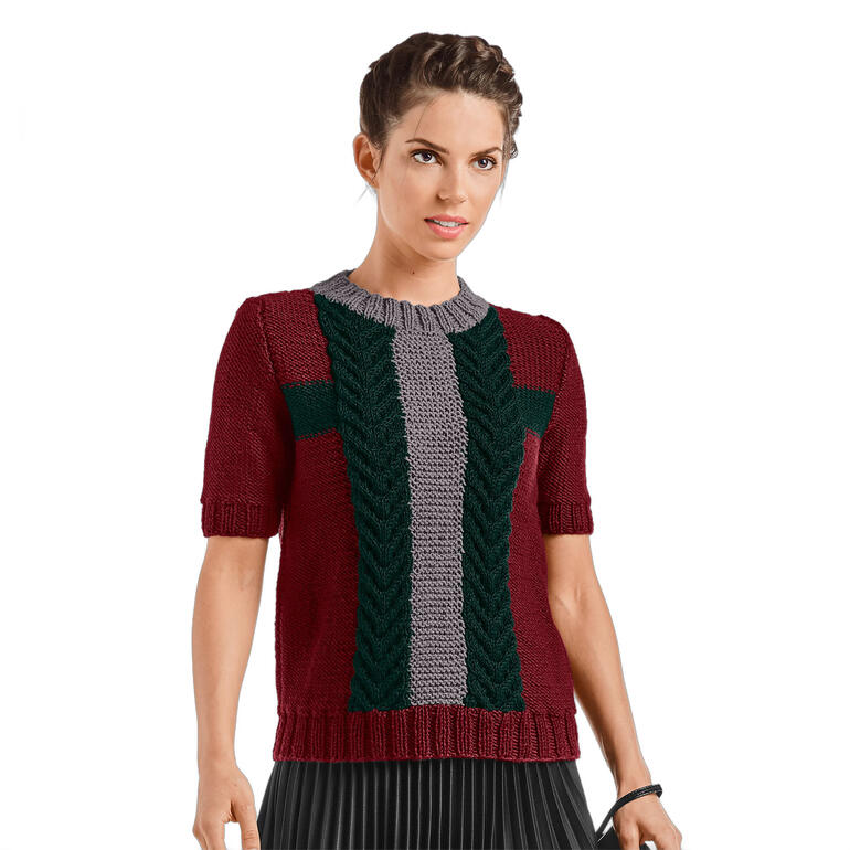 Dame in rot-grauem Damenpullover aus Merino-Classic, lächelt in einem Park.