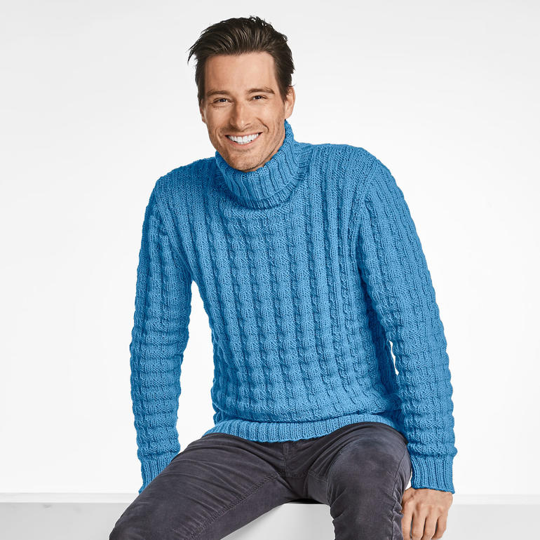 Herren-Rollkragenpullover in Blau, sitzend und lächelnd, auf einem neutralen Hintergrund.