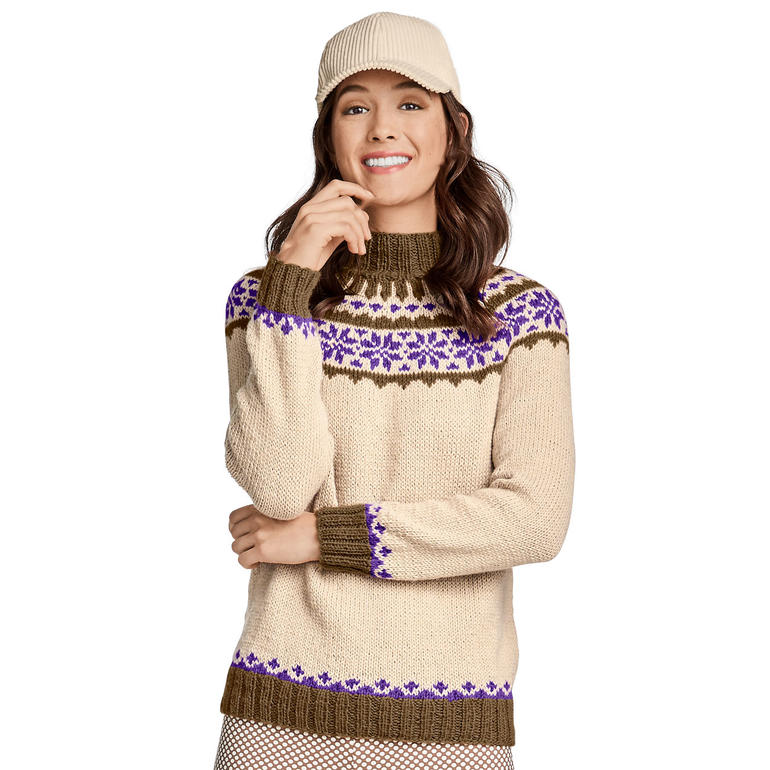 Beige Pullover mit lila und braunem Muster, lässig getragen, vor neutralem Hintergrund.