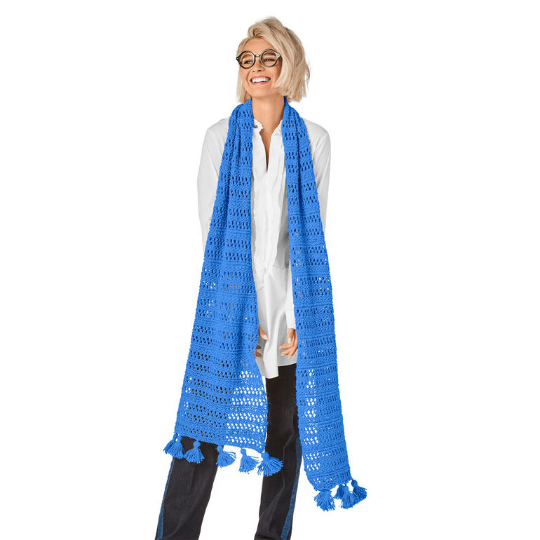Blauer Schal mit Quasten, lässig um die Schultern getragen von einer Frau.