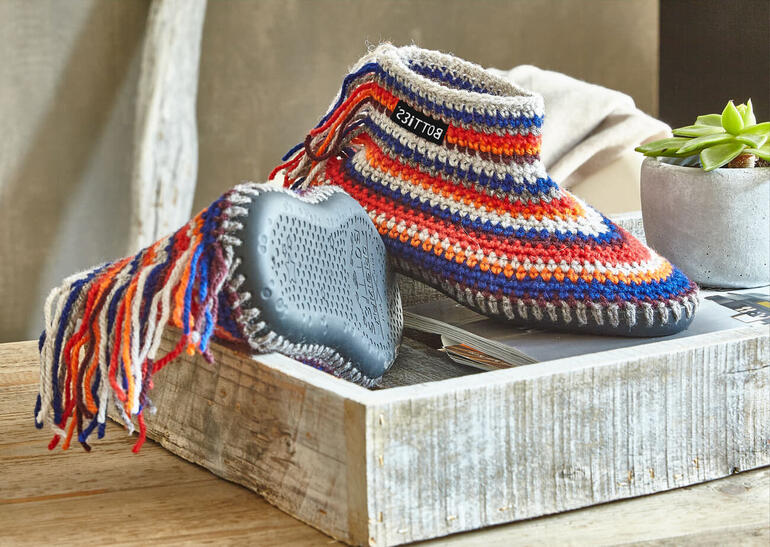 Botties aus Landwolle in bunten Farben, auf einem Holztisch.