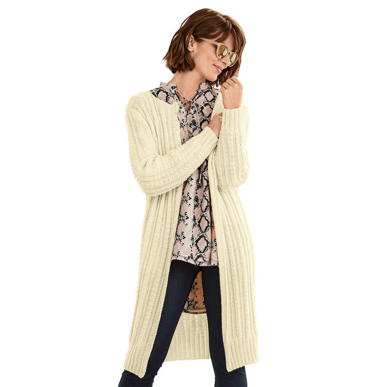 Dame in hellem Mantel aus Merino-Wolle, posierend mit Sonnenbrille.