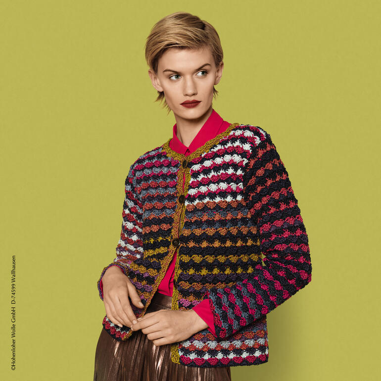 Bunte Häkeljacke, getragen von model vor buntem Hintergrund.