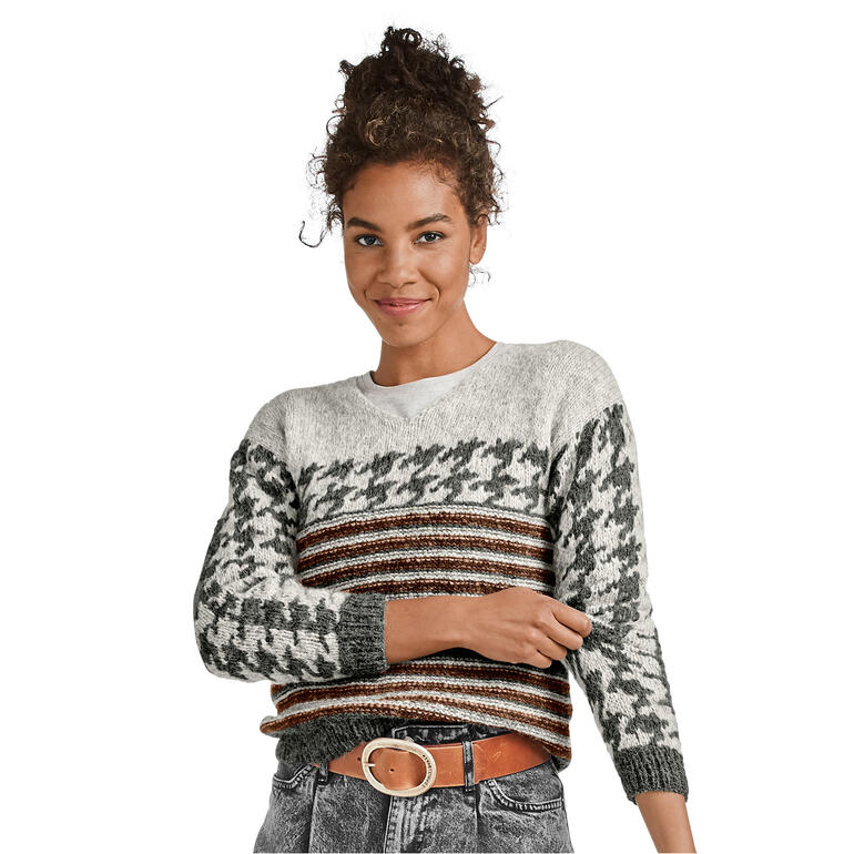 Frau in gestreiftem Pullover umarmt sich lächelnd.