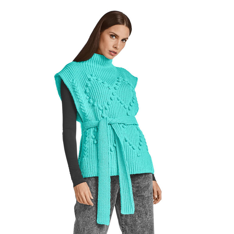 Turquoise Überwurf mit Gürtel, elegant getragen über einem schwarzen Shirt.