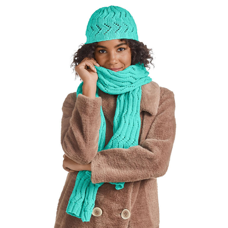Mütze und Schal aus Inja in Türkis, lässig um den Hals gewickelt.